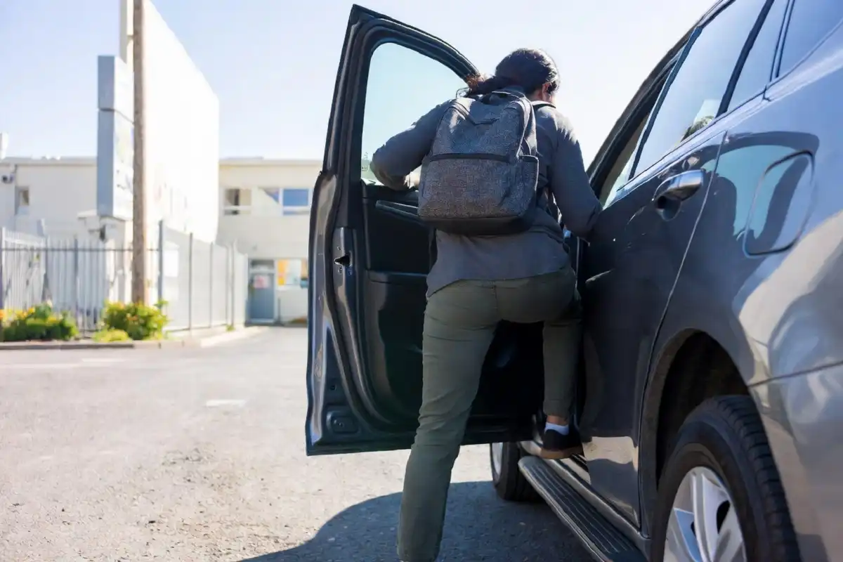 Person getting into a car for a medical transportation ride