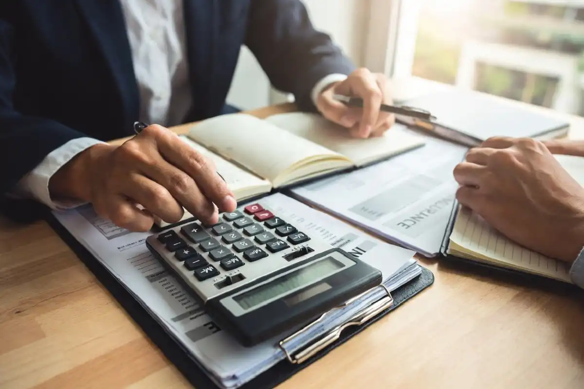 Person reviewing home health care costs with paperwork and a calculator