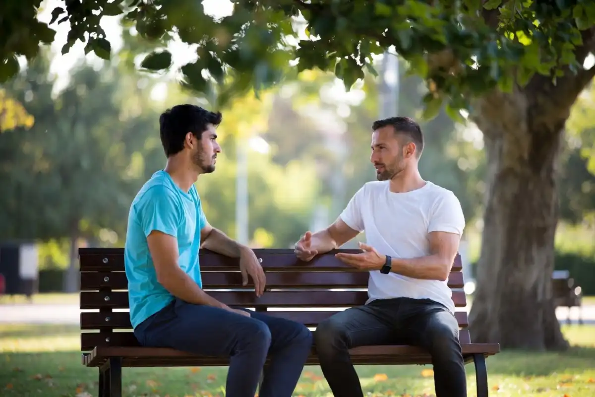 Two male friends having an honest conversation outdoors
