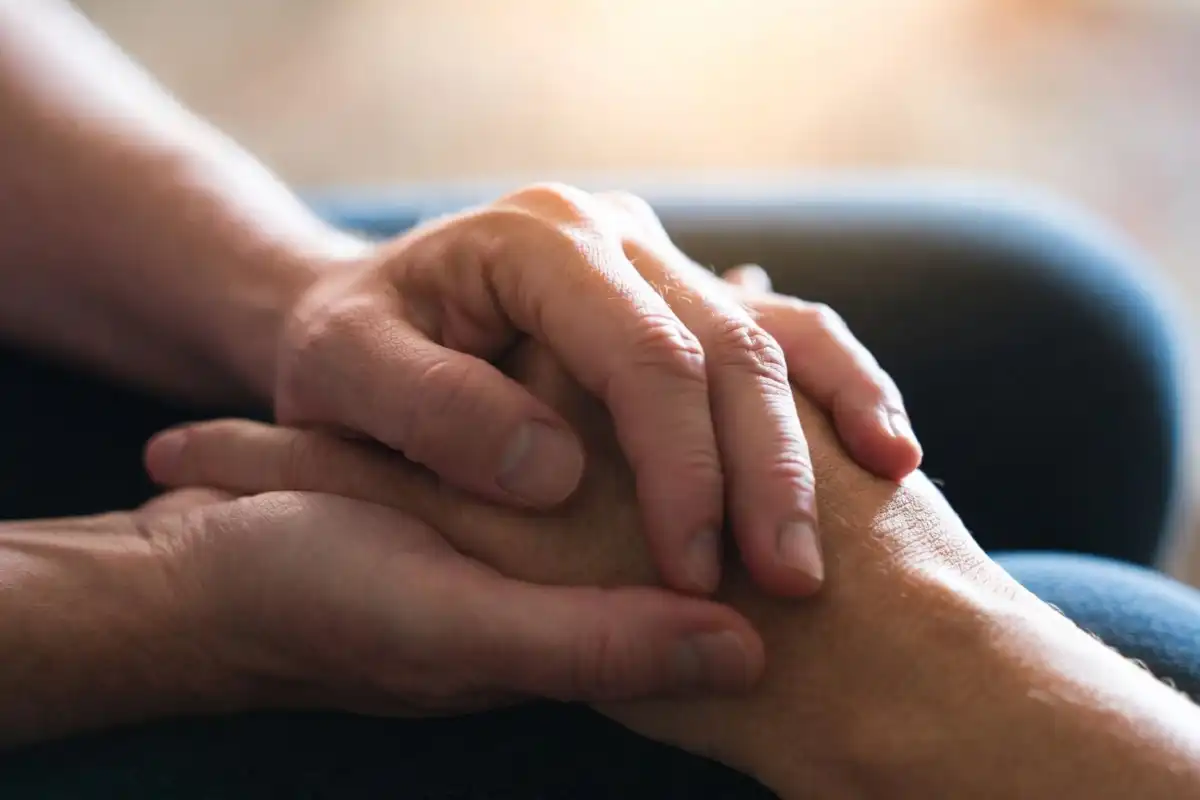 Hands clasped together representing resilience and support in the Randy Travis health recovery story